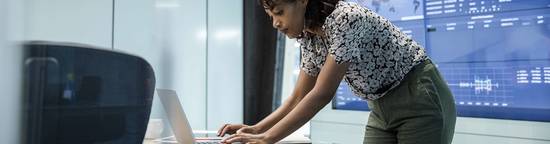 Woman Using Computer In Newsroom