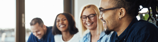 A group of peoples smiling in an office setting.